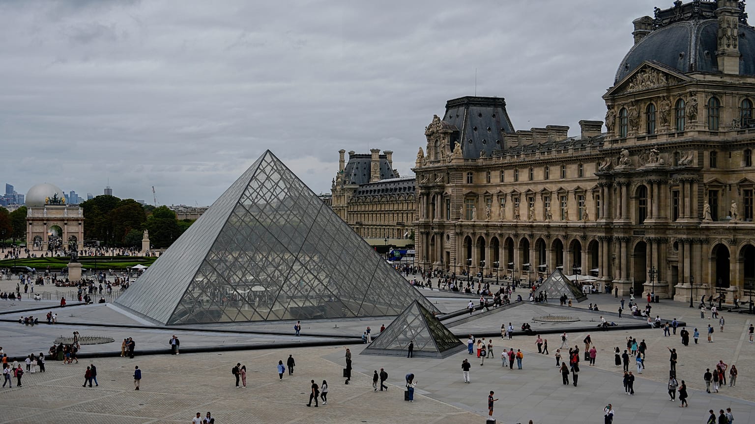 FILE. People walk outside the Louvre museum in Paris. 31 Aug. 2025. 