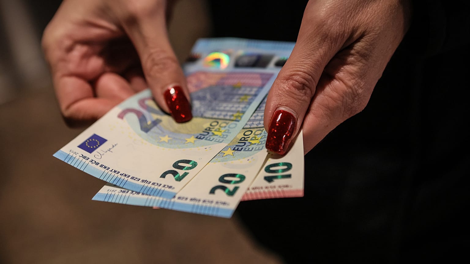 A person poses with euro banknotes withdrawn from an ATM in Sofia, Thursday, Jan. 1, 2026, as the country joins the euro currency union.