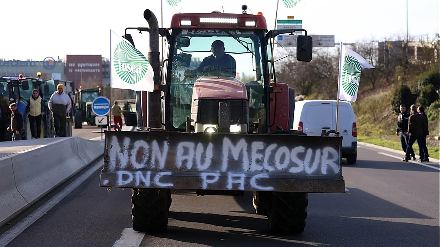 A French farmer drives his tractor to block a main road during a protest against the Mercosur trade deal with South American nations, December 2025