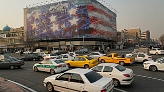 A billboard with a damaged aircraft carrier with damaged fighter jets, strewn bodies, and trails of blood in Enghelab Square in Tehran, Iran, Jan. 25, 2026.