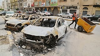 FILE: A man walks past burnt cars after clashes between heavily armed militias following the killing of a powerful warlord, in Tripoli, Libya, 15 May, 2025.