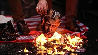 A man burns a photograph of US President Donald Trump during a rally in support of the Iranian government in Istanbul, 18 January, 2026
