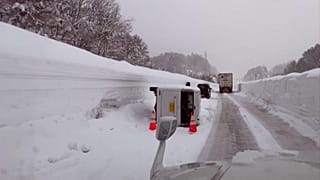 Vehicles move through snow