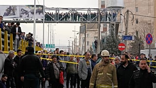 People gather as they watch a fire raging at the Jannat market in western Tehran