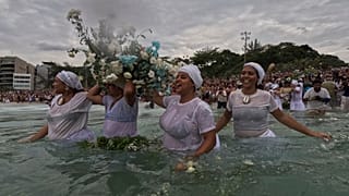 Devotees take flowers into the waters of Arpoador Beach to offer Yemanja, the African goddess of the sea,