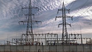 A woman walks by an electrical power distribution station in the Danube port city of Calarasi, southern Romania, Sunday, Dec. 11, 2011. 