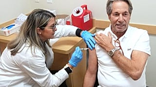 Daniel Toccin receives a COVID-19 vaccine shot as he and his wife get vaccinated against coronavirus and seasonal flu for an upcoming trip in Miami, 9 September 2025.