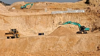 Workers use machinery to dig at a rare earth mine in Ganxian county in central China's Jiangxi province.