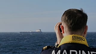 A member of the French navy watches a ship of Russia's so-called "shadow fleet" - File photo