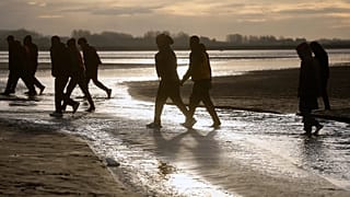 Migrants leave the beach after failing to cross the Channel and reach Britain, 6 November, 2025 
