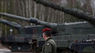 A Polish soldier walks next to the Leopard 2 tanks during a training
