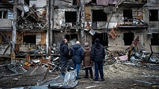 People look at the damage following a rocket attack the city of Kyiv, 25 February, 2022
