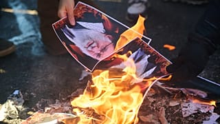 Protesters burn pictures of Iranian Ayatollah Ali Khamenei as they march in support of regime change in Iran during a protest in Toronto, 1 February 2026
