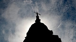 A statue of liberty is silhouetted as it stands atop the Old Bailey in London, 8 August, 2019