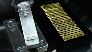 FILE - An employee of Pro Aurum gold house lifts 1 Kg silver bars of 999.9 purity besides 1 Kg gold bars in the safe deposit boxes room in Munich, Germany. April 25, 2026