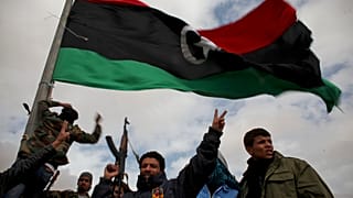 Libyan volunteers wave a pre-Qaddafi flag on the outskirts of the eastern Libyan city of Ras Lanuf, Tuesday, 8 March 2011.