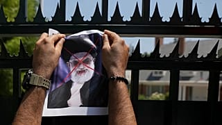 A defaced poster of Ayatollah Ali Khamenei is placed by a demonstrator on a gate of Iran's embassy in Santiago, 20 January, 2026