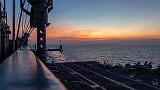 The sun sets over the Nimitz-class aircraft carrier USS Abraham Lincoln in the Indian Ocean, 22 January, 2026