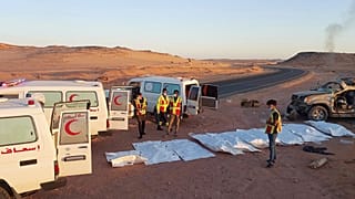 Rescuers prepare to carry bodies of 12 Sudanese migrants killed in a car crash in the desert, 30 May, 2025