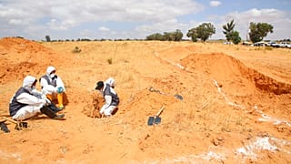 FILE - Libyan Ministry of justice employees dig out at a site of a suspected mass grave in the town of Tarhouna, Libya, Tuesday, June 23, 2020