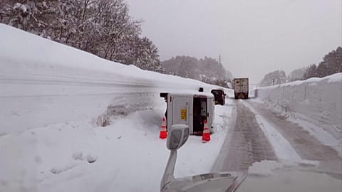 Vehicles move through snow