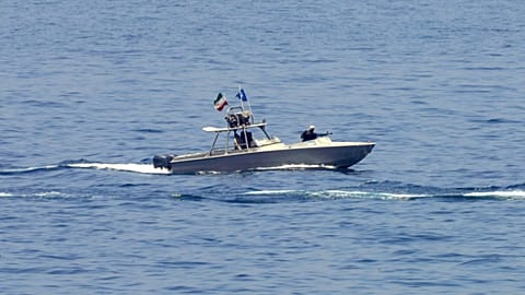 FILE: An Iranian Revolutionary Guard vessel watches an American warship in the Strait of Hormuz, May 19, 2023.